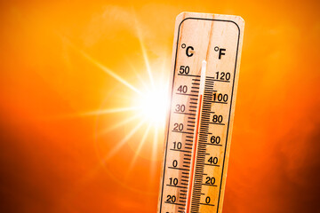 Thermometer showing high temperature with sun shining bright